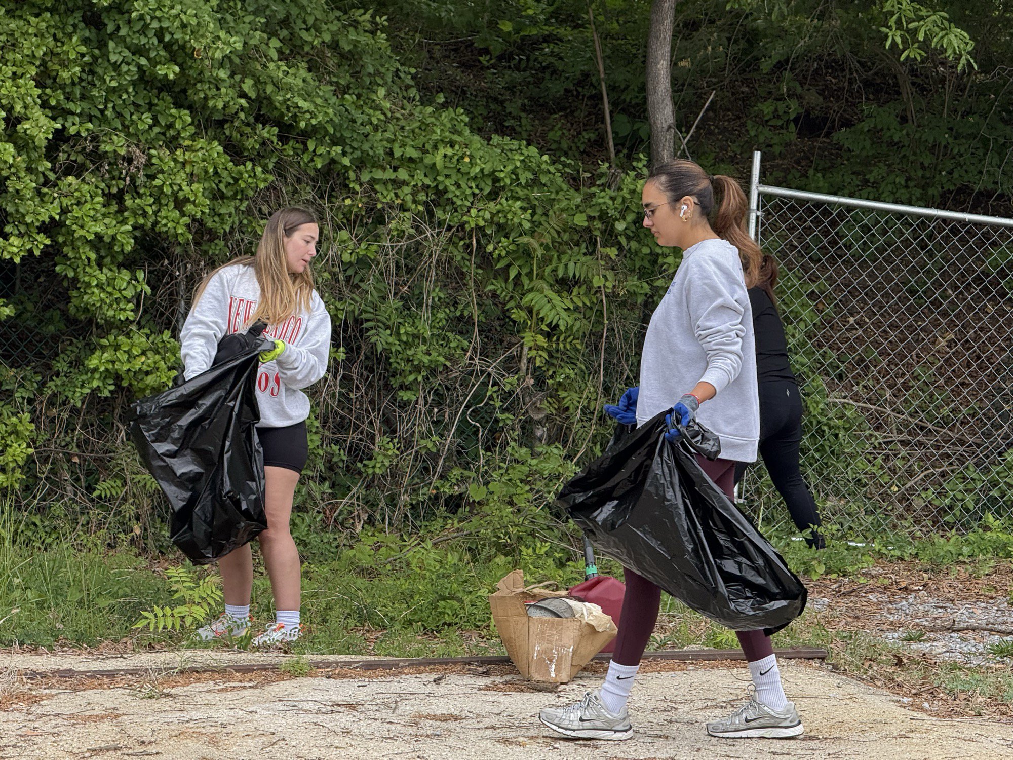 Bagging trash along the fence line