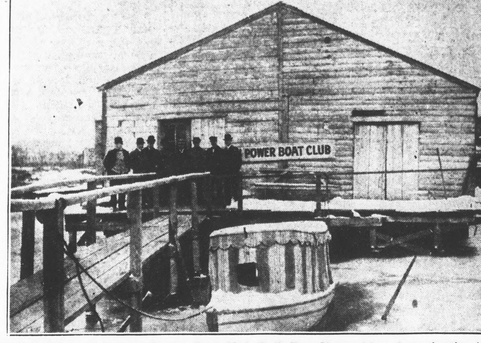 A Washington Times photograph of the club’s first clubhouse, a wooden boathouse lettered “Power Boat Club,” with members on the dock at the foot of Eleventh Street Southeast.