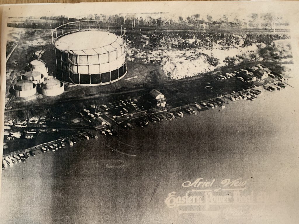 An early aerial photograph of the Eastern Power Boat Club, its docks lined with boats on the Anacostia beside the gasworks’ great cylindrical storage tank.