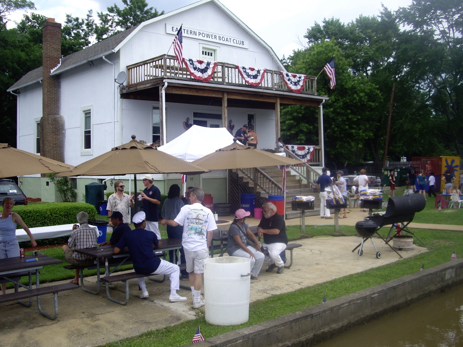 The picnic tables filling up below the clubhouse porch